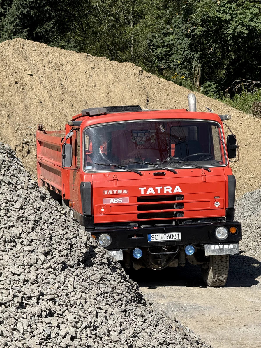 Czerwona wywrotka Tatra na placu firmowym.